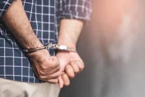 drug conspiracy suspect being arrested in handcuffs